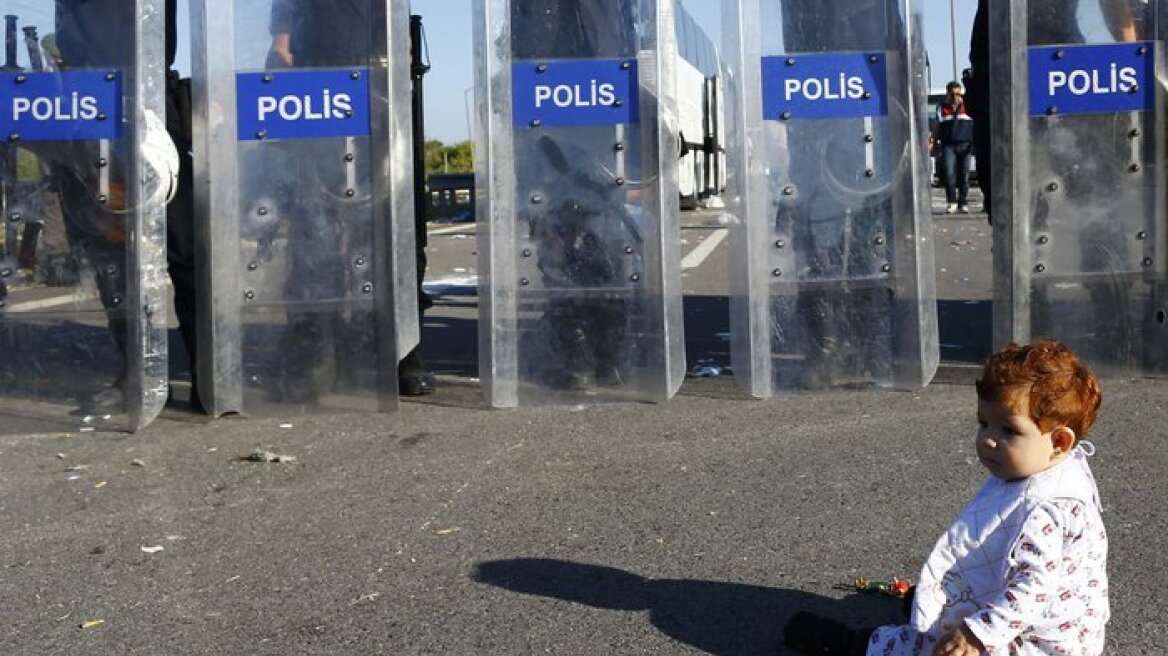 Συγκλονιστική εικόνα: Ένα προσφυγόπουλο κάθεται μπροστά από το μπλόκο των αστυνομικών